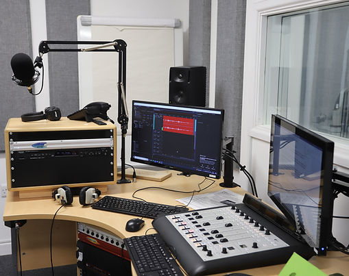 Archie Stevens talking into a microphone in the studio with a happy expression.