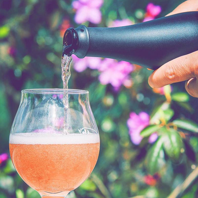 A bottle pours mead into a glass