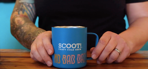 a Scoot! Craft Cold Brew Coffee tumbler held by two hands