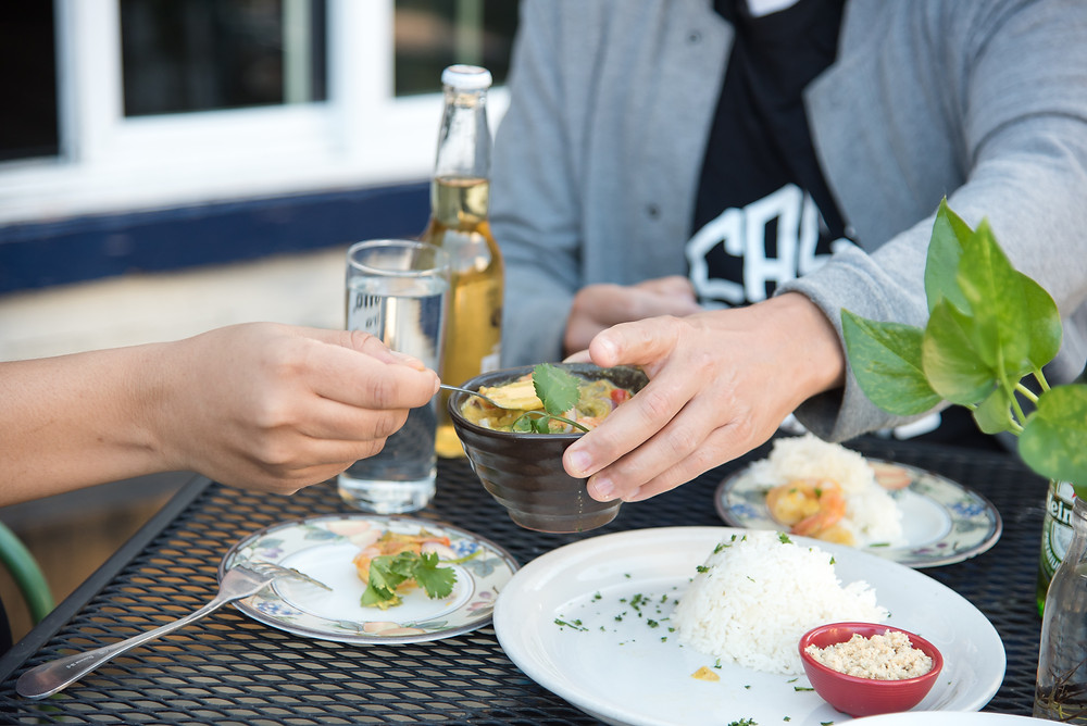 Two people share plates at a table at Casa Brazil, an authentic Brazilian restaurant in Pittsburgh