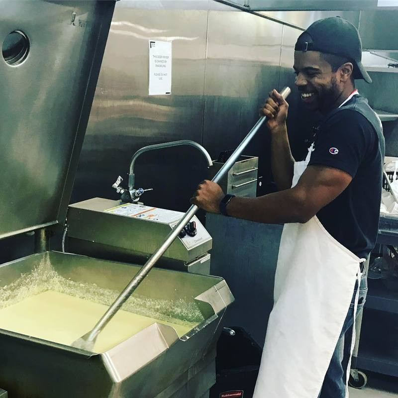Myles Powell, owner of 8 Myles, stirs mac and cheese in the Union Kitchen accelerator kitchen