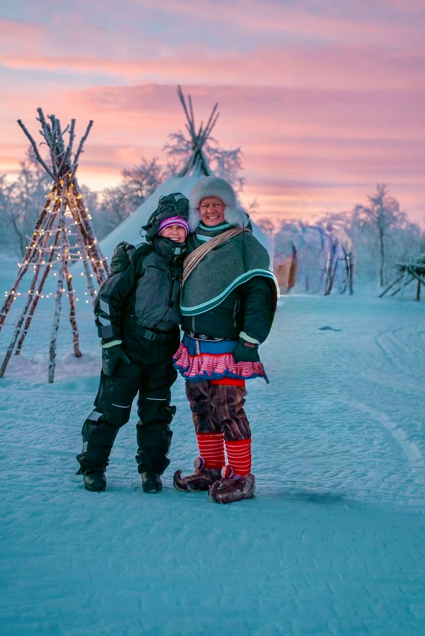 experiência com o povo Sami no Ártico durante inverno com cabanas tradicionais ao fundo