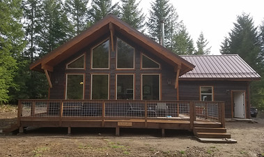 exterior shot of home with window wall, dark brown siding, lighter brown trim