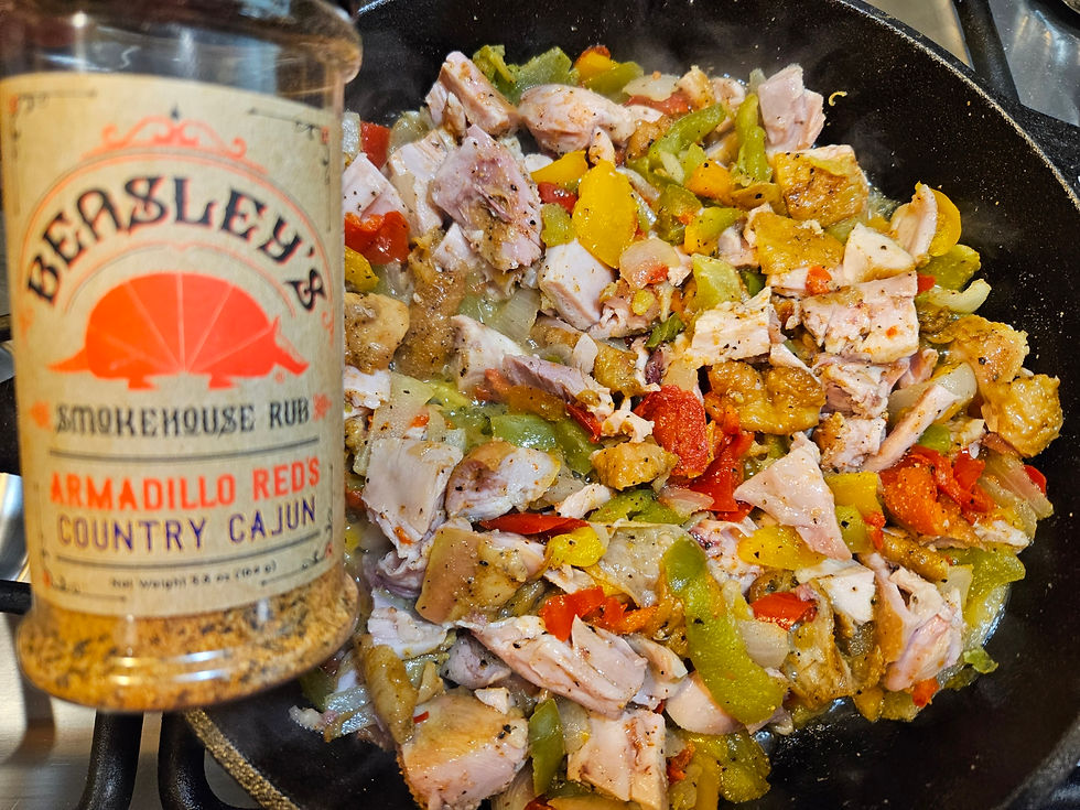 Eye-level view of a cast-iron skillet with Cajun turkey and vegetables cooking