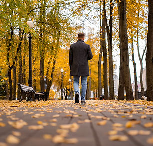 Young man walking alone outdoors in autumn city, navigating life transitions and change