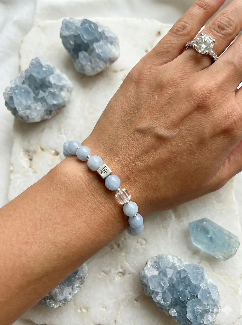 Handcrafted Aquamarine Still bracelet shown on a wrist, highlighting the soft internal glow of the blue quartz against precis