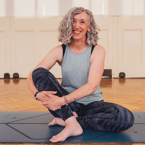 Yoga teacher sitting on yoga mat