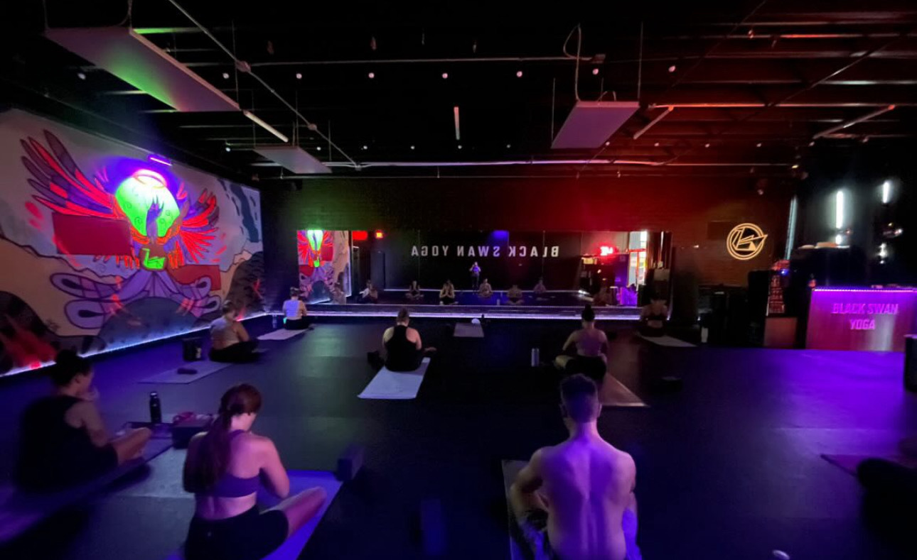 Stage view of glow yoga room with red and green lights at Black Swan Yoga Midtown Phoenix.
