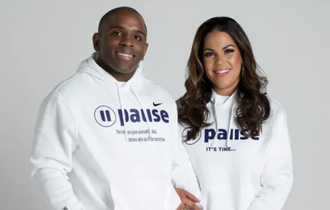 Owners Evan and Lisa Benson smiling in Pause hoodies at Pause East Cobb Atlanta wellness studio.