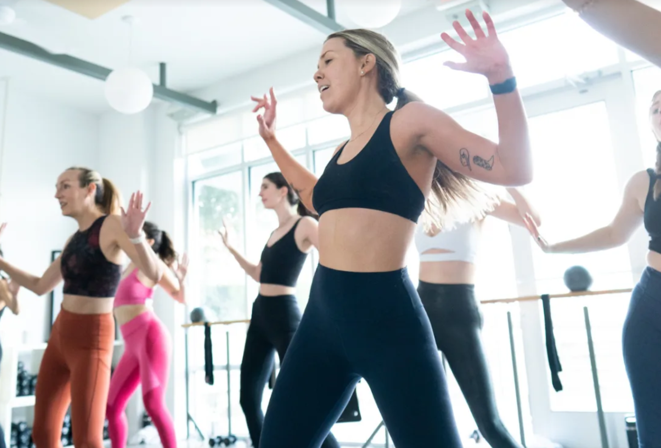 Close view of woman punching the air in a HIIT boxing segment inside Motiv Fitness Austin’s bright studio.