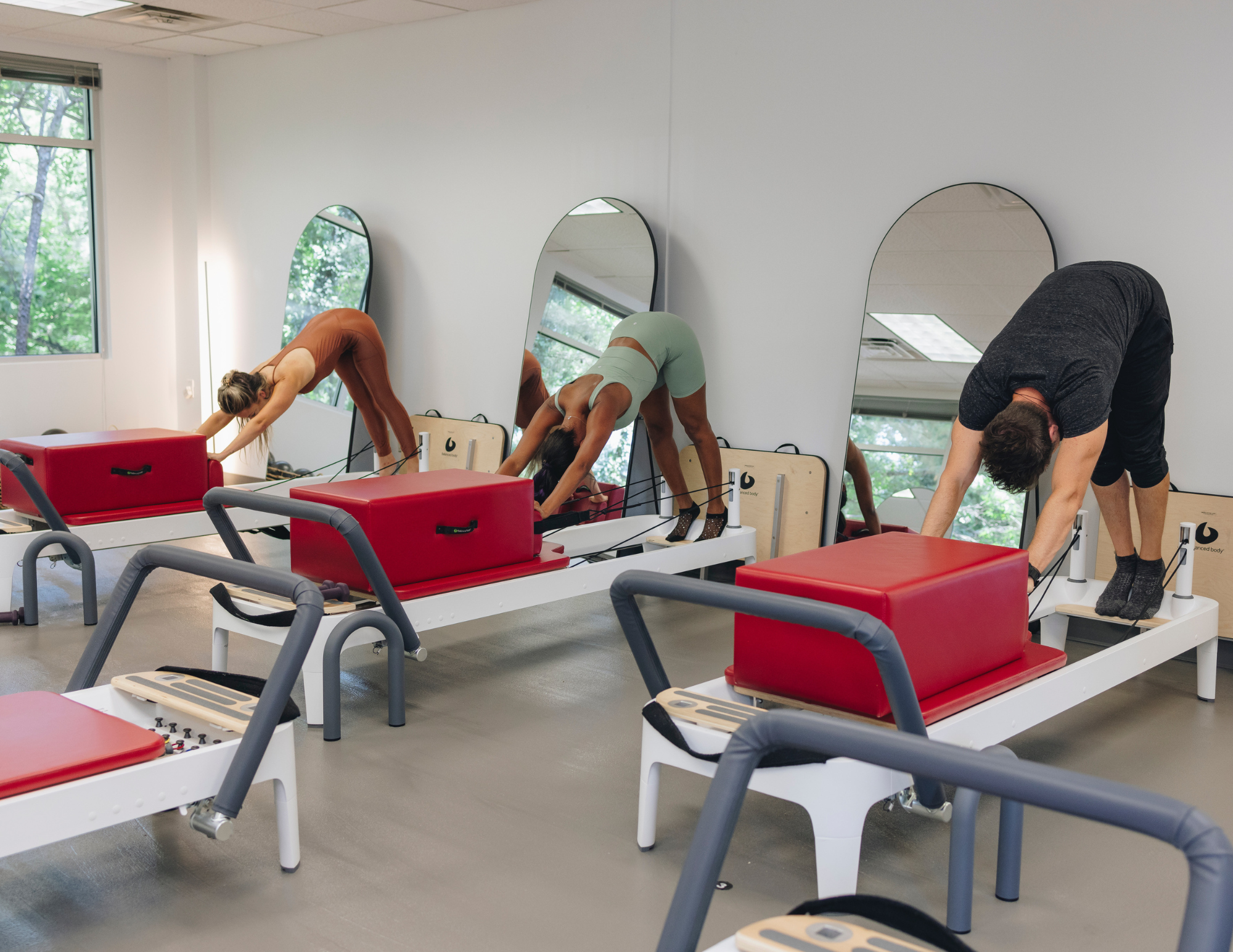 Side view of empty reformer row awaiting class at Naked Mind Studio Roswell Atlanta.