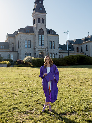 Kansas State University graduate poses infront of anderson hall 