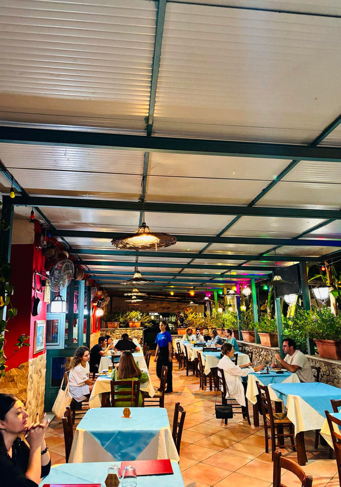 Terrazza animata del ristorante Bella Italia Tropea con tavoli e ospiti.
