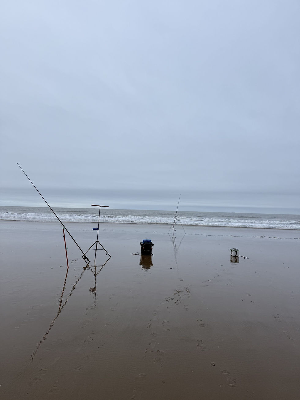 Eye-level view of a rocky shoreline with fishing rods set up along the edge
