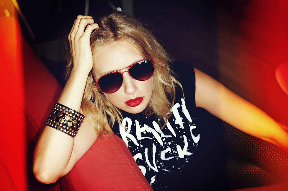 _beautiful provocative blonde woman dressed sexy 80s style lying in a red sofa in a design