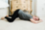 woman doing the open knee chest position on the floor
