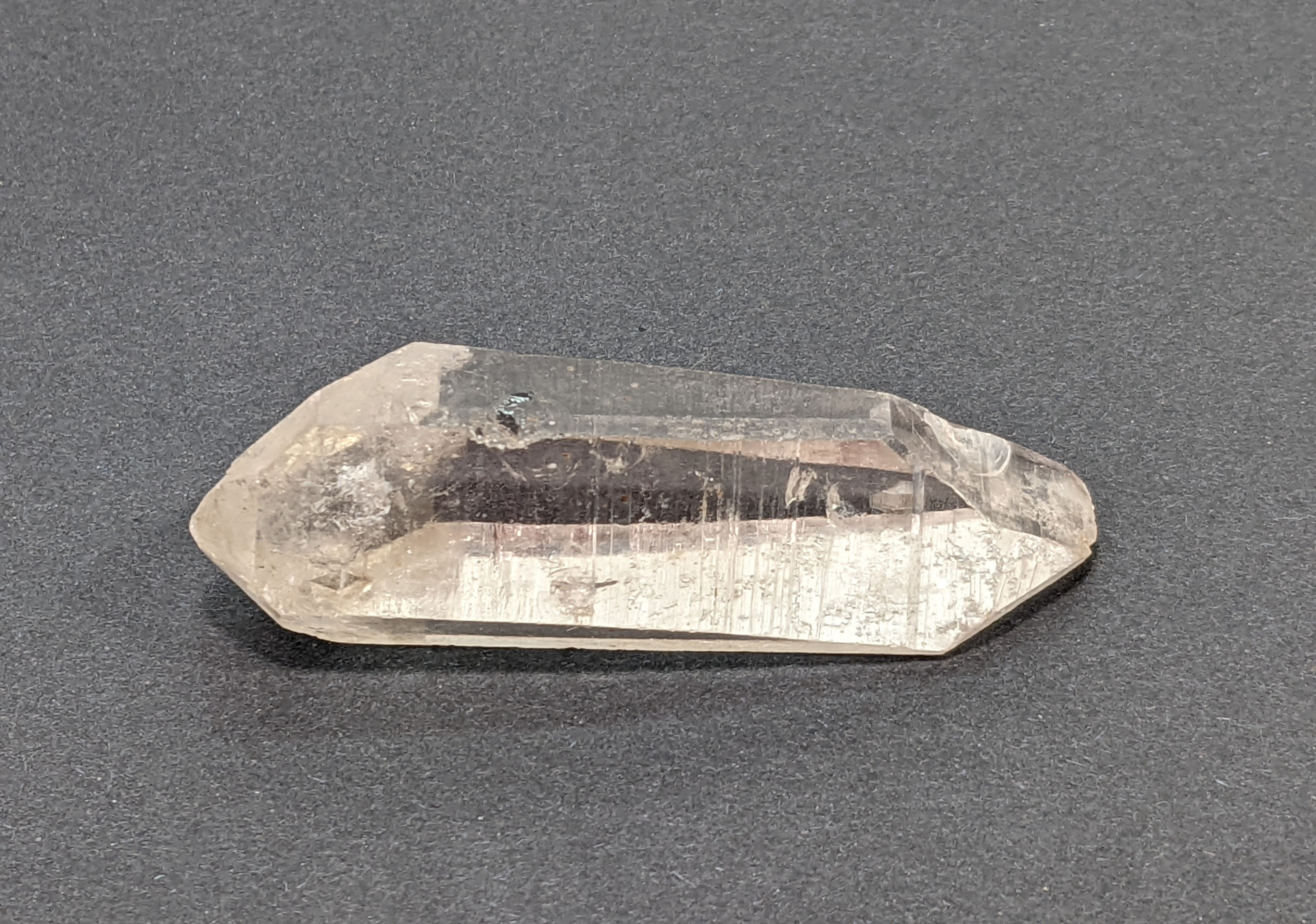 Raw Lemurian Quartz standing upright with visible growth lines.