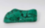 A polished malachite freeform stone with striking layers of rich green and bold, flowing patterns.