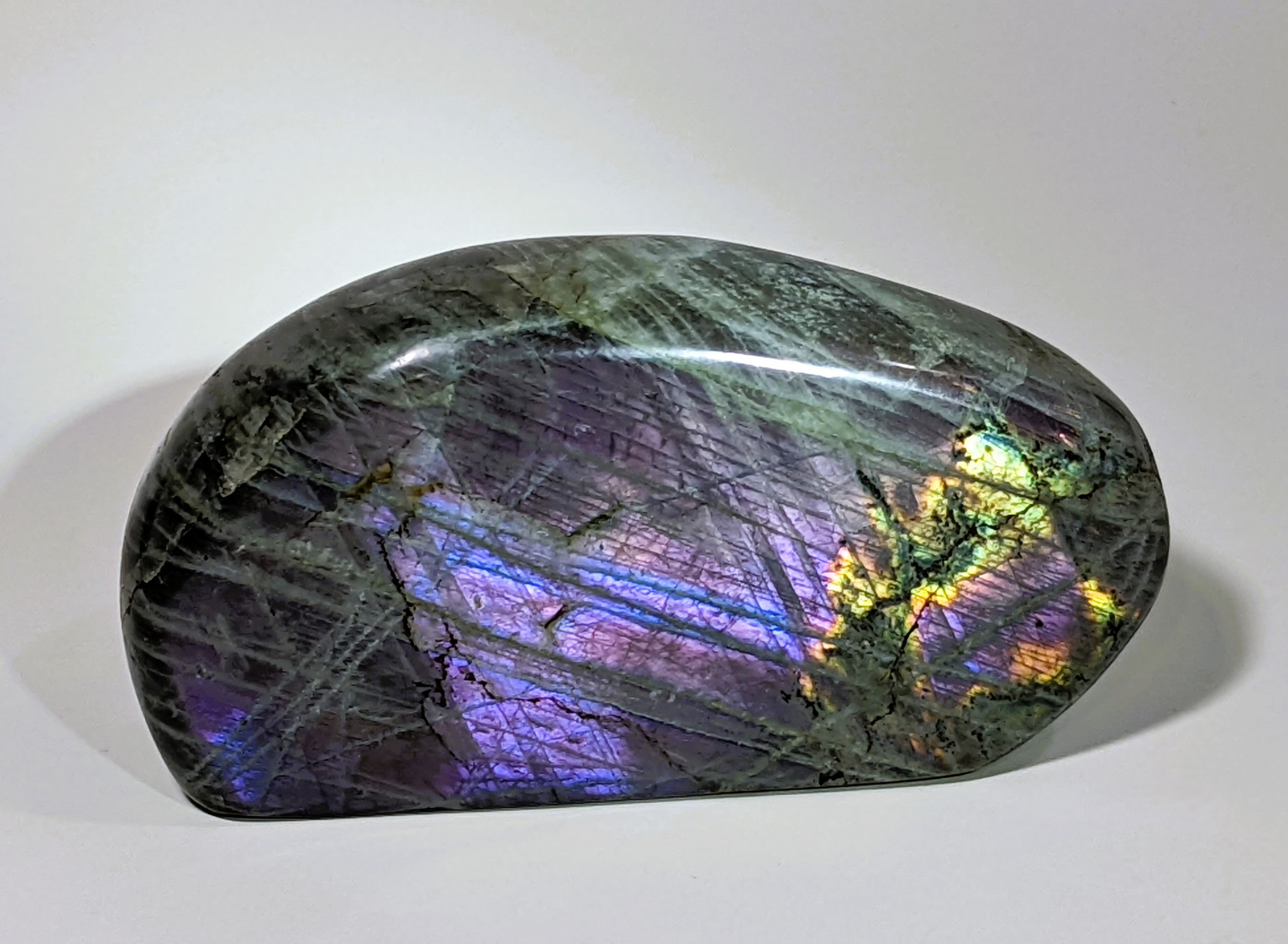 Purple Labradorite with flashes of blue, green, and gold, known for its mystical energy, promoting intuition