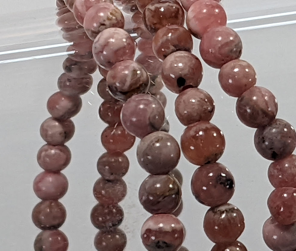 Rhodochrosite beaded bracelet with soft pink and rose-red hues, showcasing natural banding patterns.