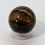 Thumbnail: Tiger’s Eye carved sphere with golden-brown bands and chatoyant sheen