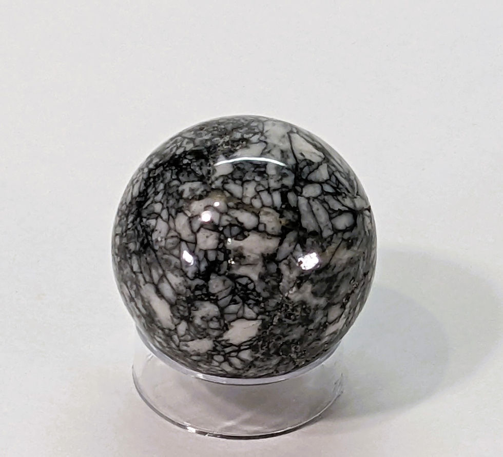 Thumbnail: Polished Pinolite sphere with natural black and white mineral patterns.