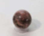 Polished Rhodonite sphere promoting compassion and emotional clarity.