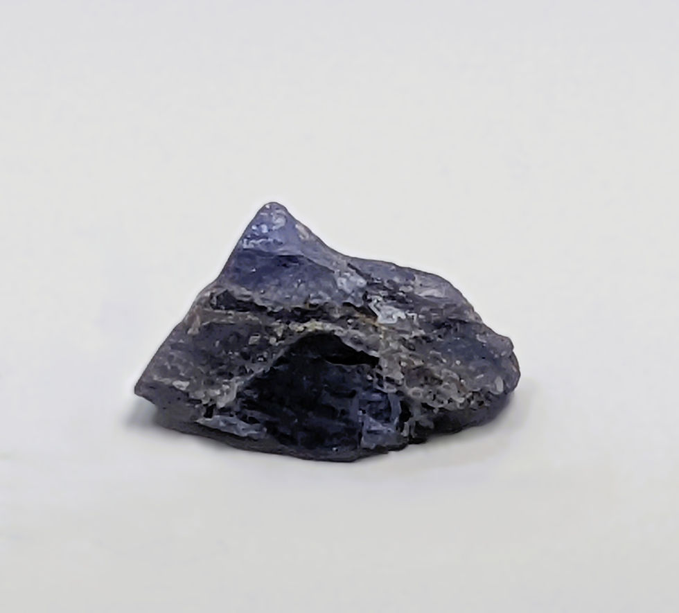 Thumbnail: unpolished tanzanite crystal with raw edges and soft blue coloration