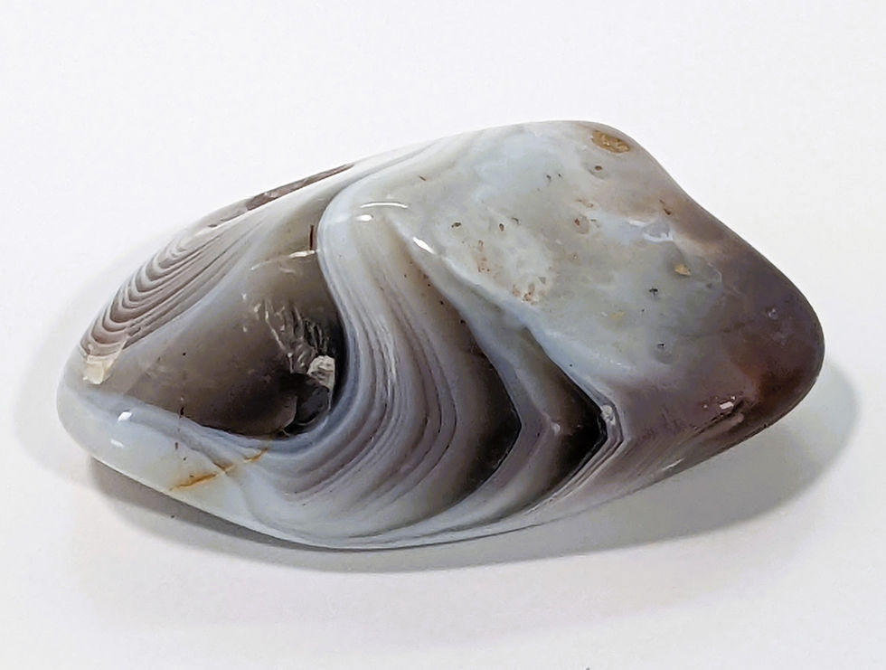 Thumbnail: Smooth Botswana Agate tumble showcasing layered gray, pink, and brown banding.