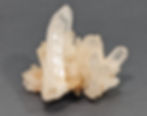 Raw clear quartz cluster with bright, radiant tips.