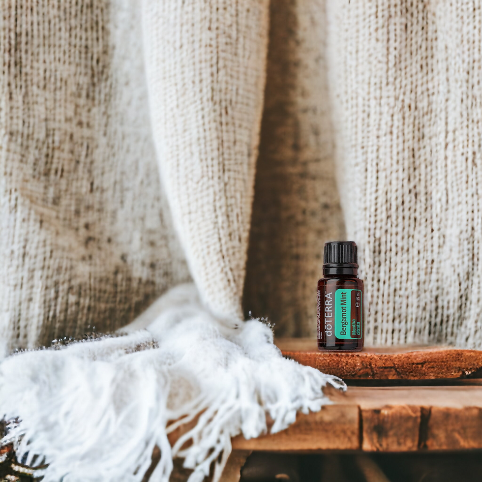 dōTERRA Bergamot Mint essential oil bottle on a wooden shelf beside a white woven blanket, warm cozy scene