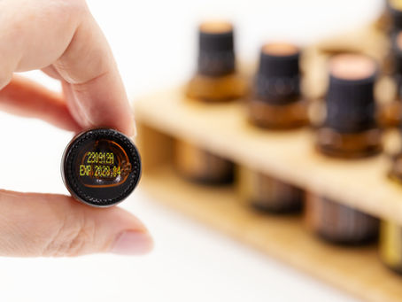 A bottle of essential oil in dark glass bottle clearly showing quality ID number and expiry date