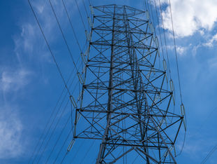 High voltage electrical transmission tower infrastructure delivers essential power across national grid system during peak energy demand showcasing critical utility distribution network