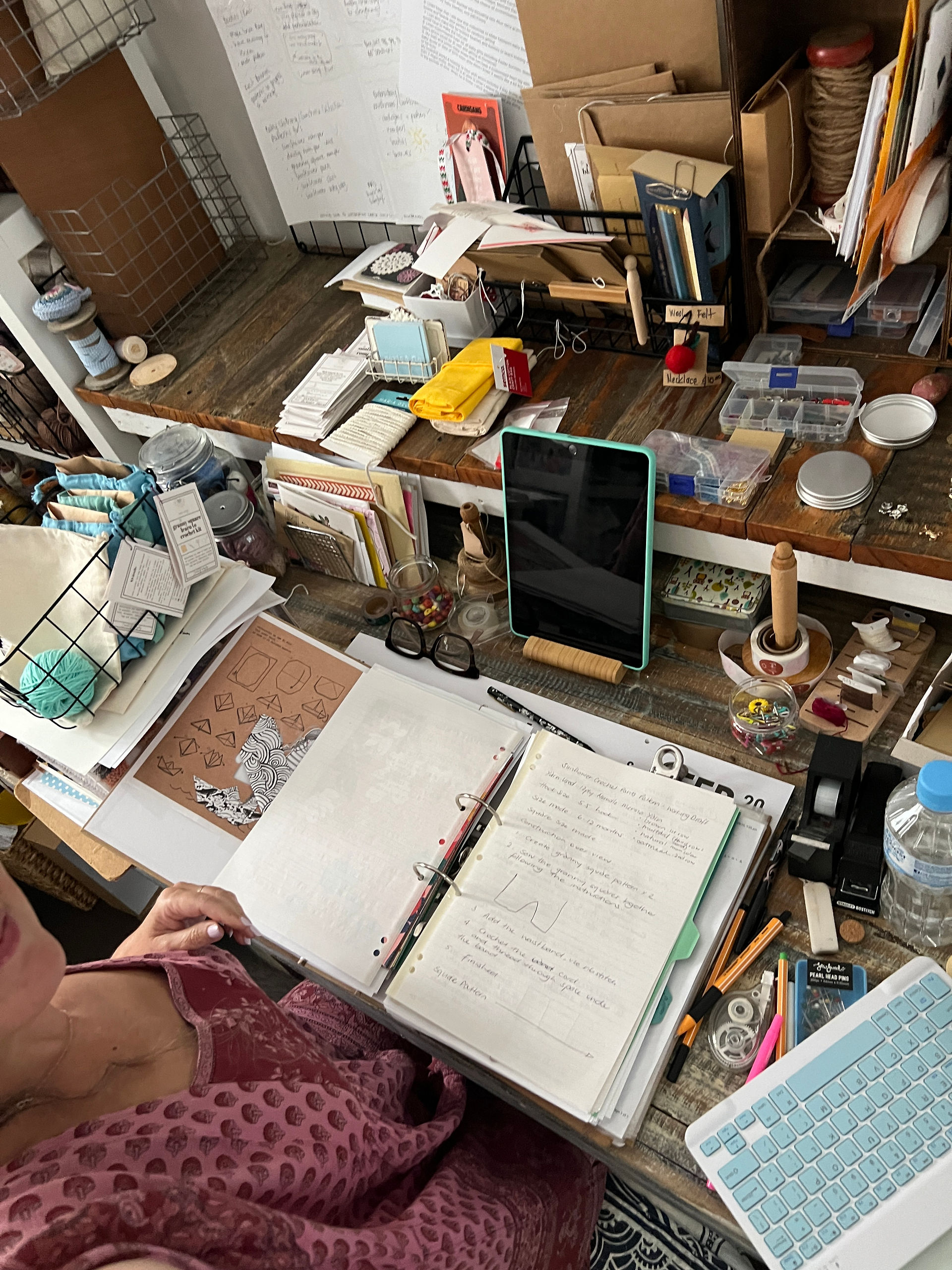 Creative workspace with open ring binder journal, collage materials and stationery tools spread across a desk during a junk journaling session