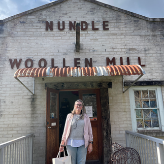 Lovely lady standing outside of Nundle Woollen Mills carrying bags