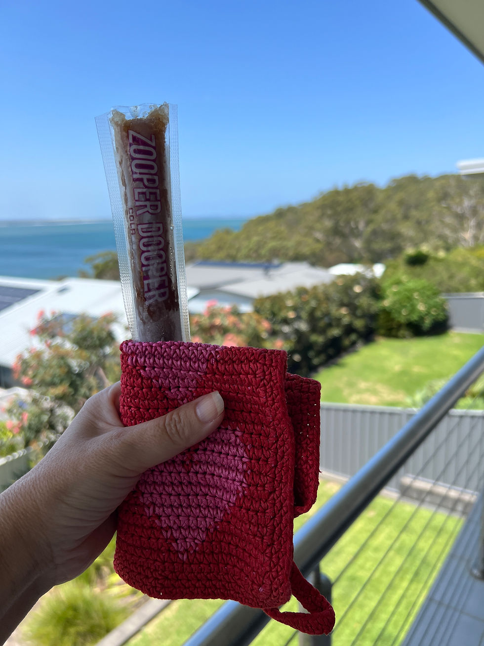 a zooper dooper held outdoors on a warm summer day near the water