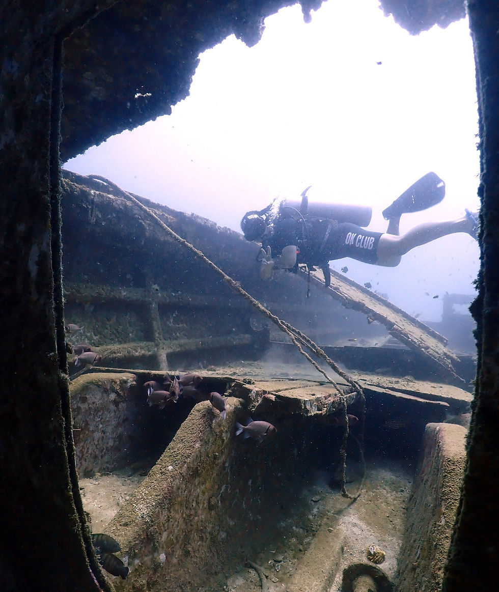 A scuba diver exploring the wreck in Koh Ma