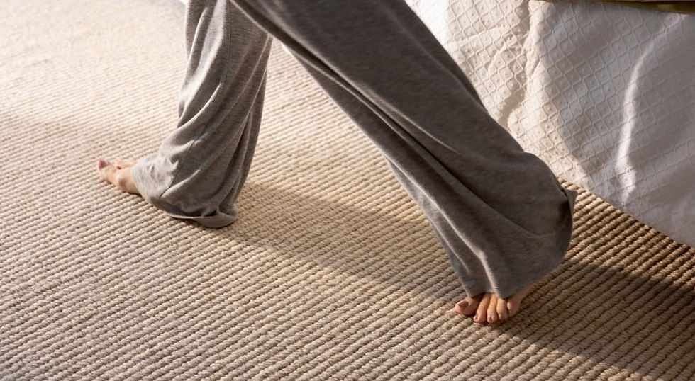 Custom made wool rug in a bedroom, with a woman walking barefot over the luxurious material