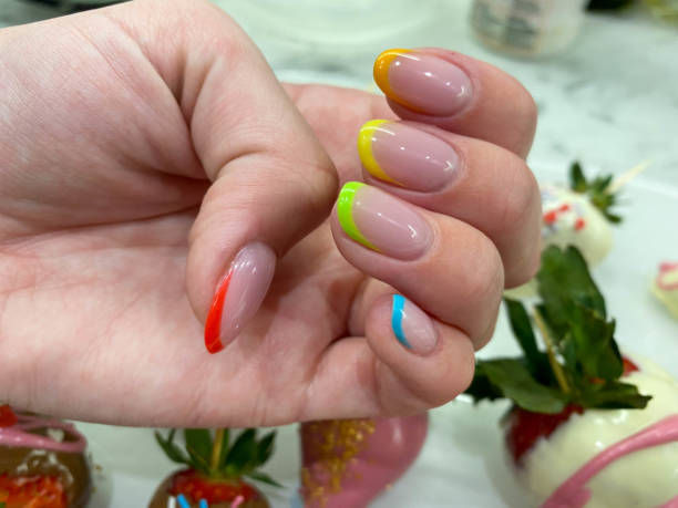 Hand with neon French tip nails and red stripe