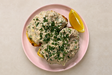 Creamy herby tuna on toast served on thick sourdough with microgreens and lemon wedges.