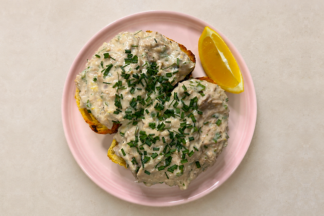 Creamy herby tuna on toast served on thick sourdough with microgreens and lemon wedges.