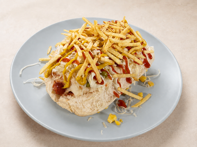Hero alt text São Paulo-style Brazilian hot dog topped with mashed potato, peas, corn, cheddar, three sauces and crunchy potato sticks.