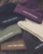 Collection of beanies with text FIND THE GOOD on display, stylish hats.