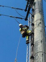 Electrician working on power pole/concrete pole