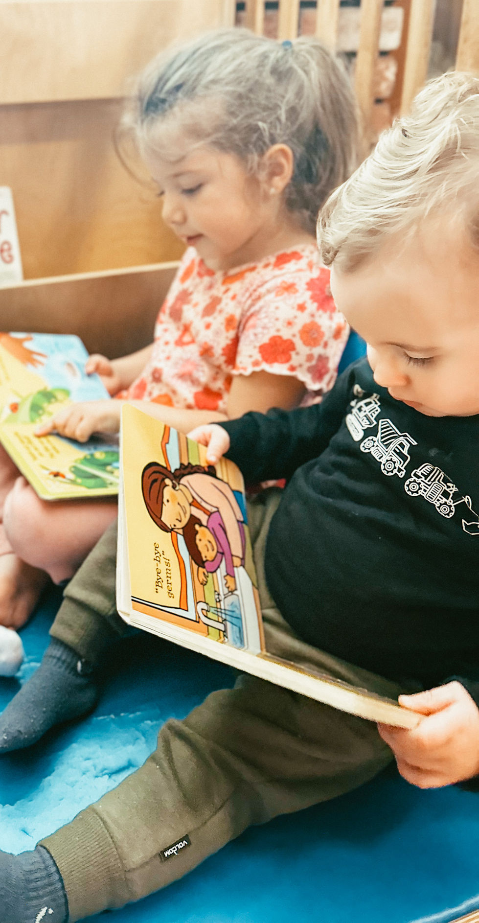Children reading colorful picture books together.