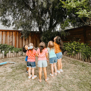 Children looking up at a tree outdoors.