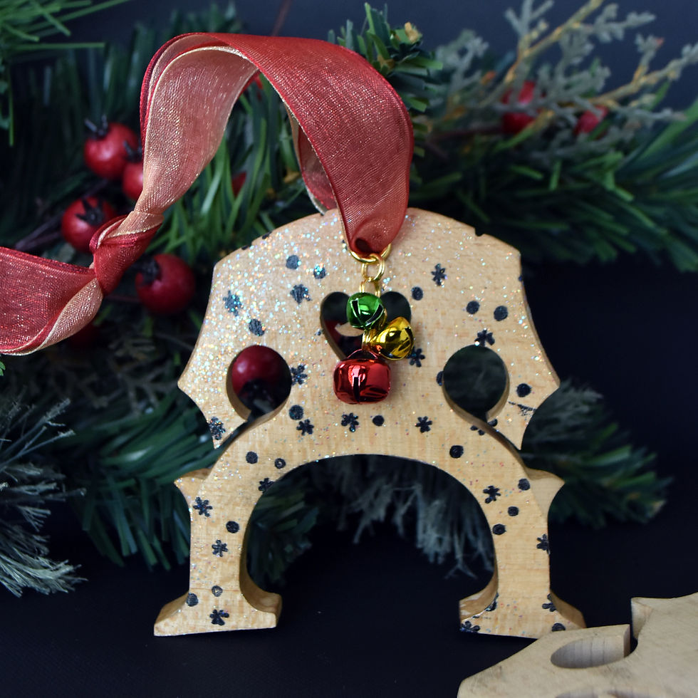 Handmade upcycled wood cello bridge Christmas ornament hanging from gold and red ribbons with a cascade of red, green, and go