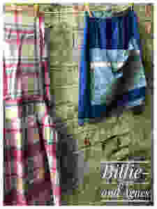 Plaid apron and blue apron hanging against brick wall