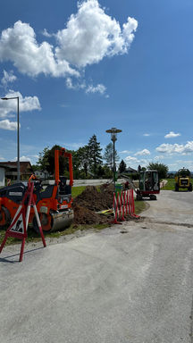 Straßenbauarbeiten mit Baumaschinen und Warnzeichen