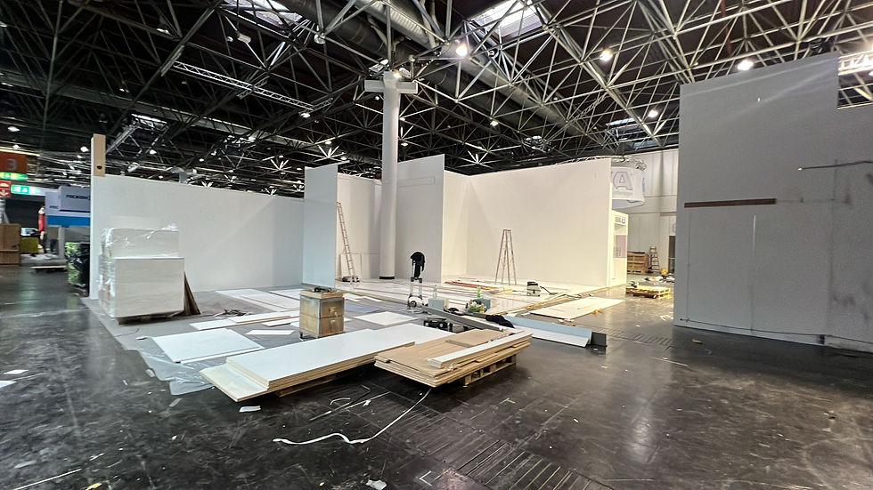 Close-up view of exhibition flooring and lighting being installed inside a fair booth